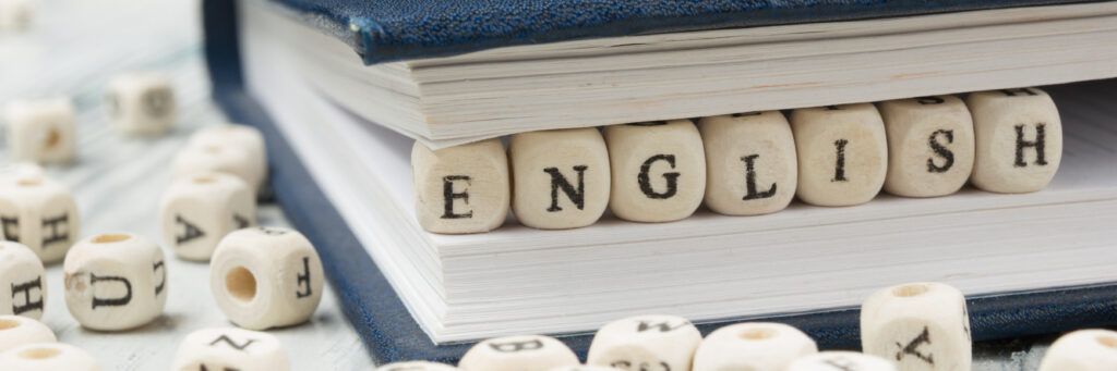 Small blocks spelling out “English” placed inside the pages of a book.