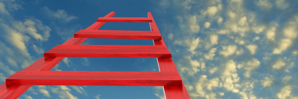 A red ladder outside placed in the direction of the blue sky above.