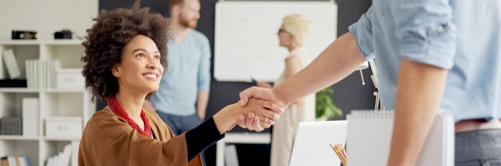 Female social worker shaking hands with a man.