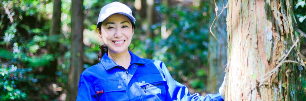 A female park ranger studying a tree in the forest.