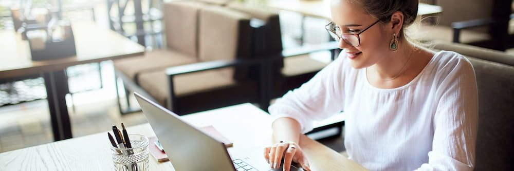 A female social worker smiling at a computer.