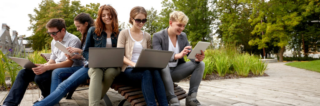 A group of online students studying together in the park.