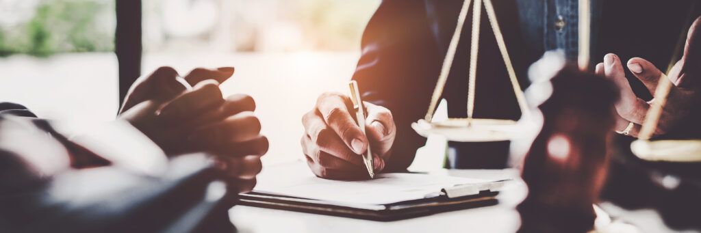 Attorney interviews client at his desk.