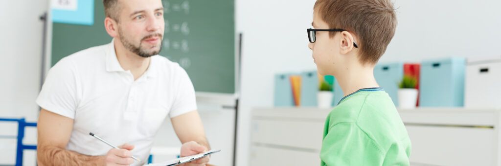 A man evaluates a child after graduating from one of the best online school psychology master's programs.