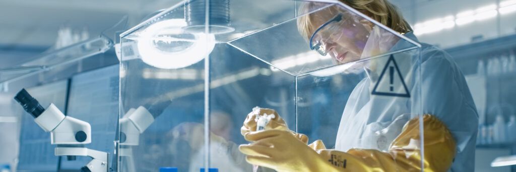 A woman with gloves handles a sample after earning her master's in epidemiology online. 